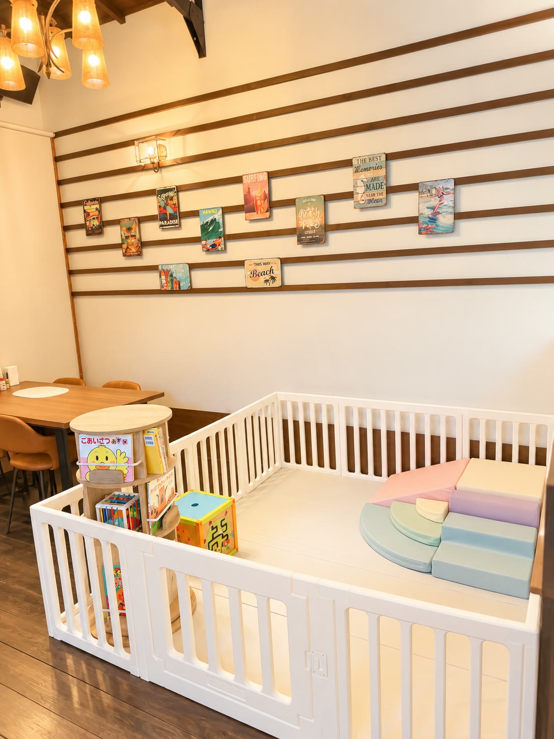 白い柵で囲まれた店内のキッズスペース。絵本やクッション遊具を備えています